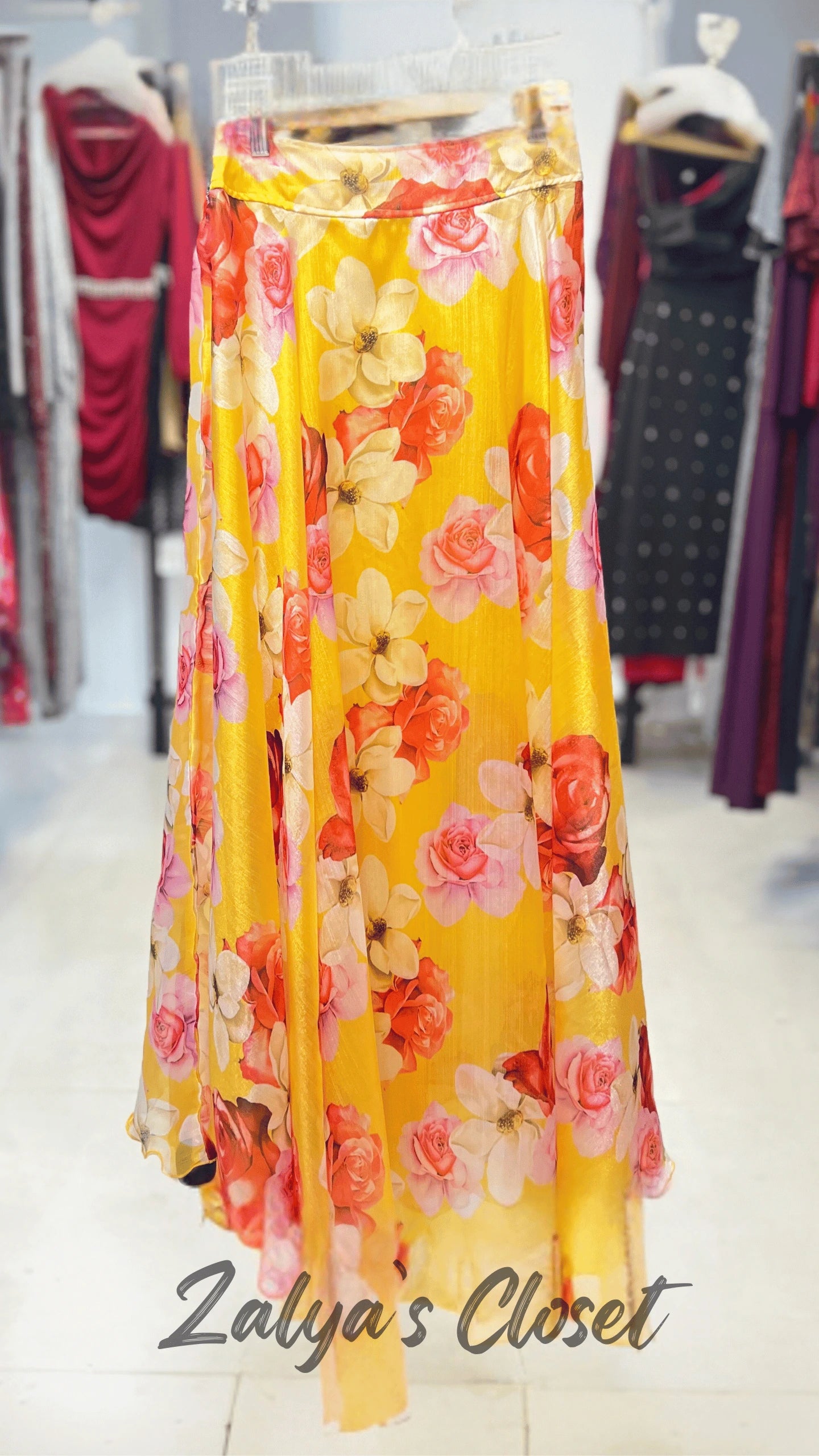 Yellow floral Skirt on a mannequin in a clothing store with 'Zalya's Closet' branding.